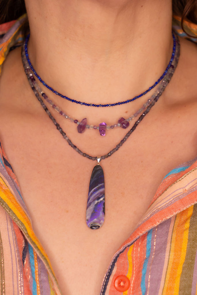 This black Opal pendant is an absolute stunner, a wonderous slice of opal heaven, black and grey base with bright purple and blue crystal swirling across and white clouds as a highlight.
