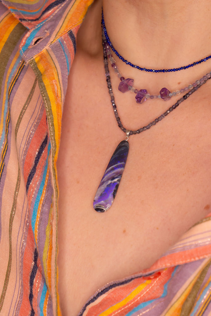 This black Opal pendant is an absolute stunner, a wonderous slice of opal heaven, black and grey base with bright purple and blue crystal swirling across and white clouds as a highlight.
