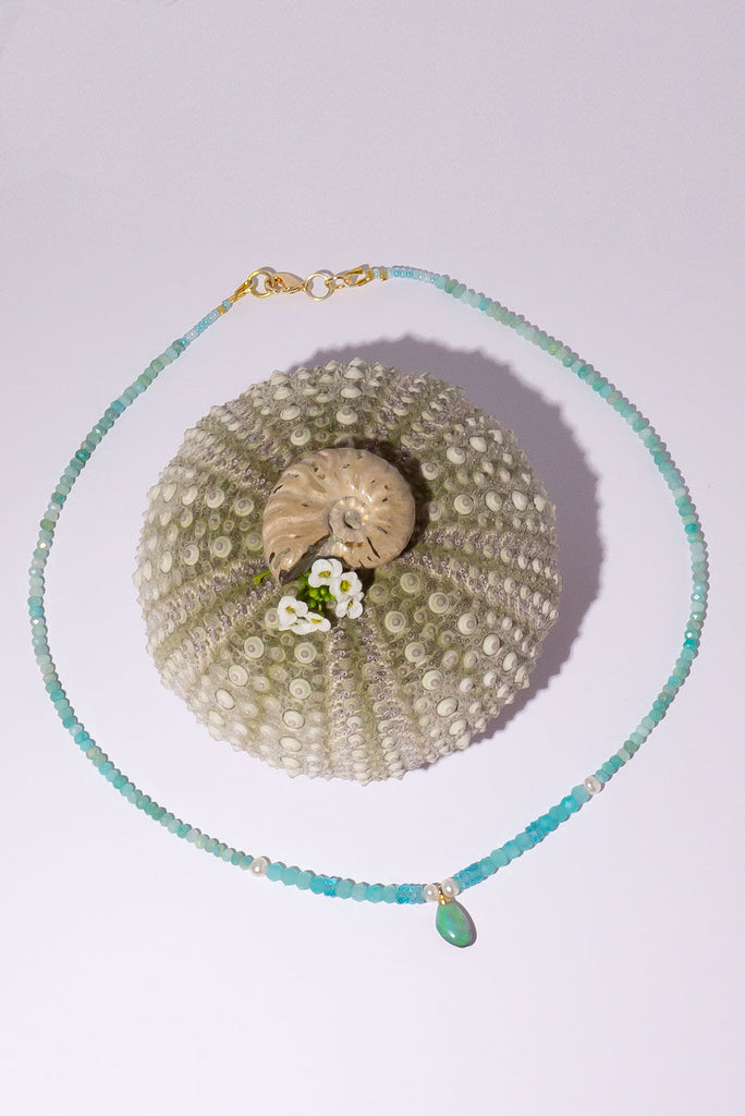 The prettiest splash of perfect wave blue, a splash of perfection, a swirl of green and teal on this tiny black opal pendant. Strung on little faceted Amazonite beads and a pretty pearls as a highlight.