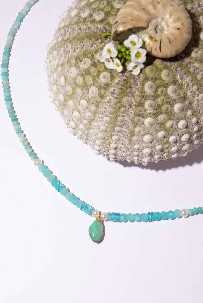 The prettiest splash of perfect wave blue, a splash of perfection, a swirl of green and teal on this tiny black opal pendant. Strung on little faceted Amazonite beads and a pretty pearls as a highlight.