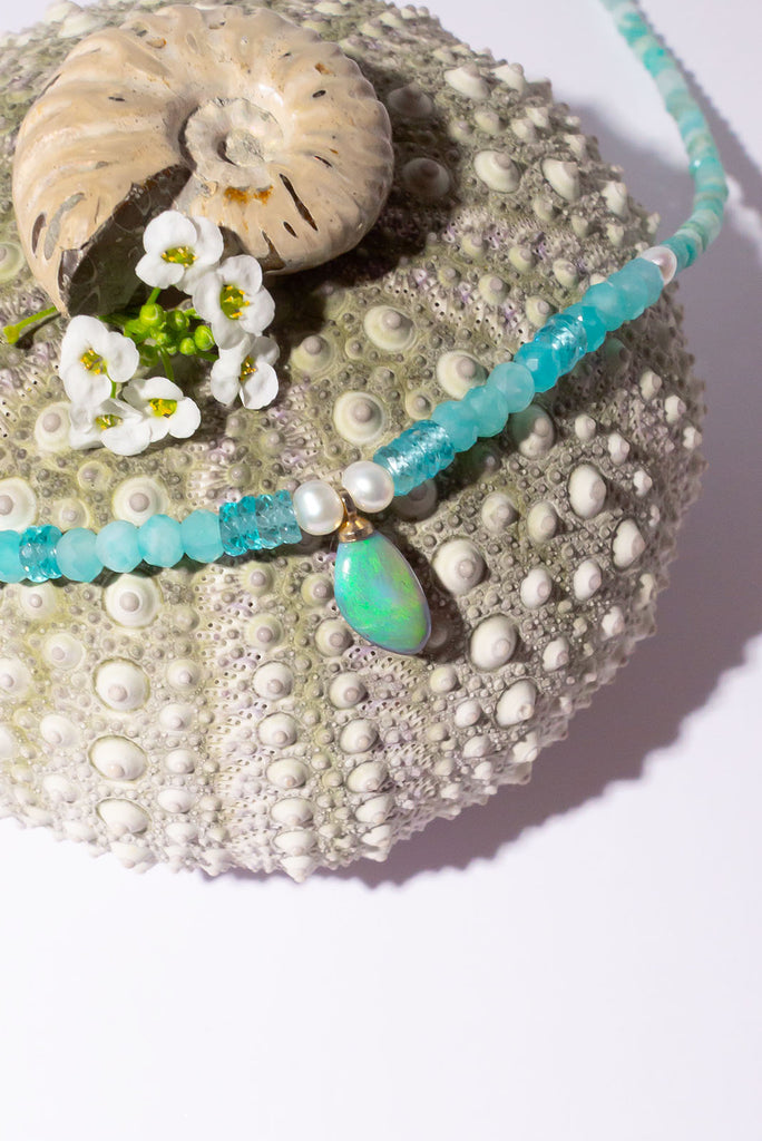 The prettiest splash of perfect wave blue, a splash of perfection, a swirl of green and teal on this tiny black opal pendant. Strung on little faceted Amazonite beads and a pretty pearls as a highlight.