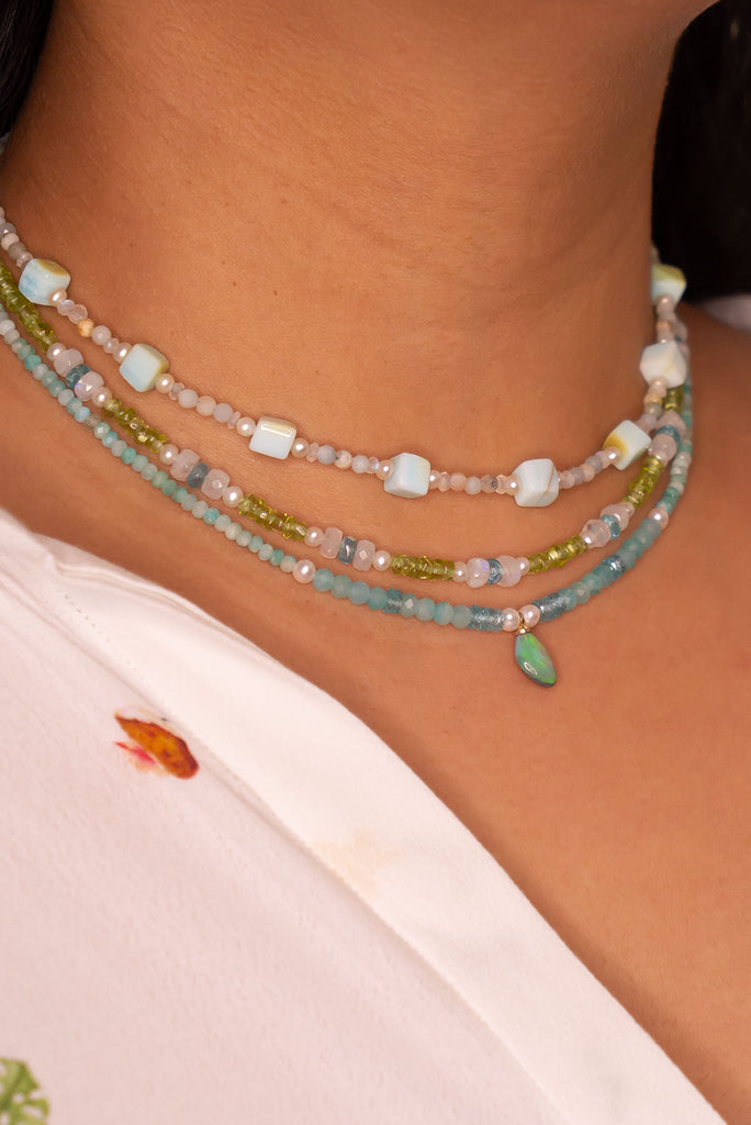 The prettiest splash of perfect wave blue, a splash of perfection, a swirl of green and teal on this tiny black opal pendant. Strung on little faceted Amazonite beads and a pretty pearls as a highlight.