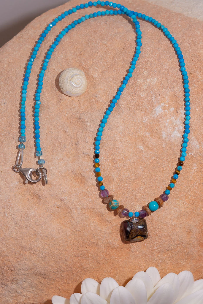Pretty, modern and sparkly, a tiny opal is the centrepiece on a bright multi stone bead gemstone necklace that glitters in the light.