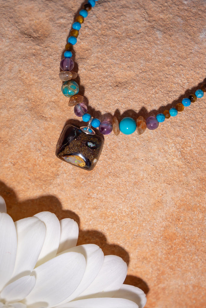 Pretty, modern and sparkly, a tiny opal is the centrepiece on a bright multi stone bead gemstone necklace that glitters in the light.