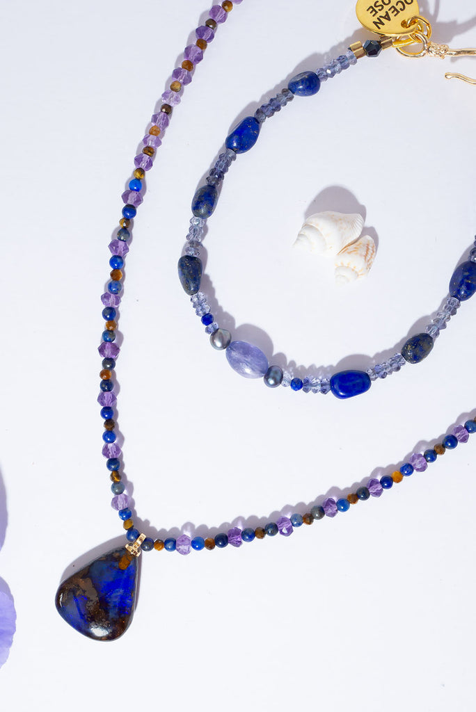 With beautiful pools of dark blue colour play found within the deep brown boulder stone this enthralling opal is complimented by the jewel tones of amethyst, lapis lazuli & shimmering tigers eye.