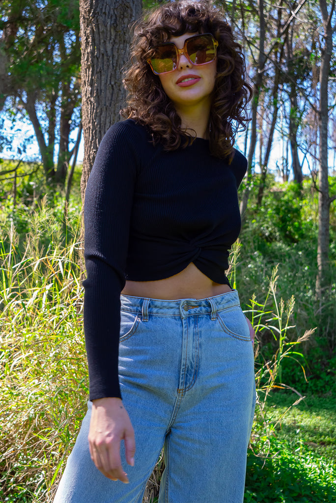 The Olivia Noir Long Sleeve Shirt is a black knit top with a twist feature on the hem. Made from viscose and nylon.