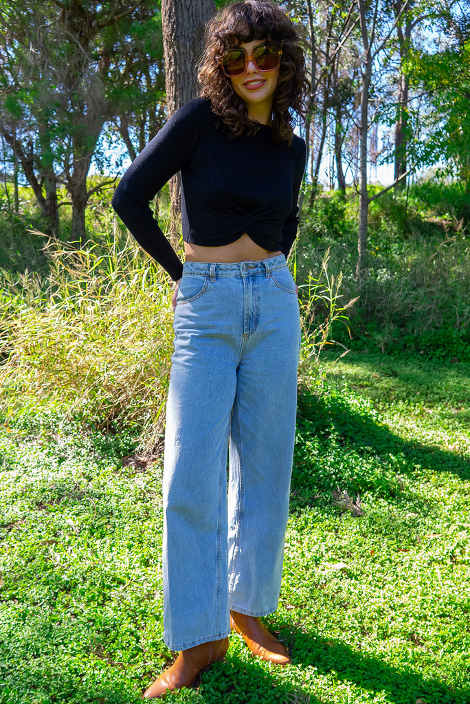 The Olivia Noir Long Sleeve Shirt is a black knit top with a twist feature on the hem. Made from viscose and nylon.