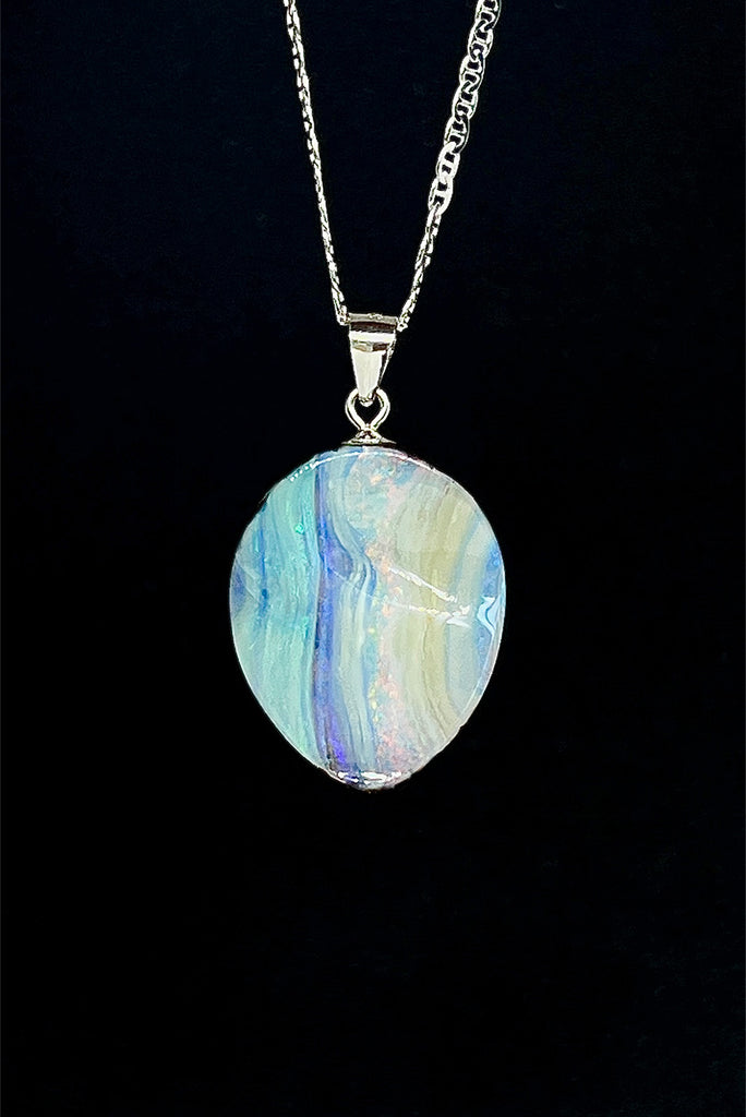 This Australian boulder Opal pendant is a beautiful feminine stone. It has a lovely sparkling flash of pink running from top to bottom, with mauve, green and blue on the sides. The surface is not flat but has a softly undulating surface.