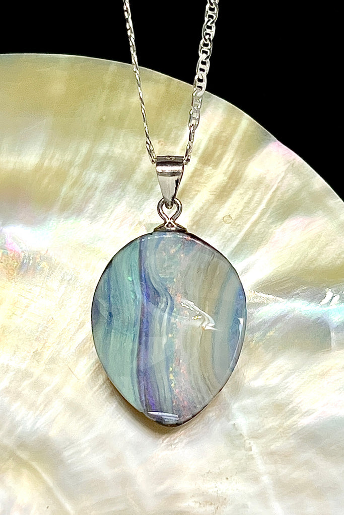 This Australian boulder Opal pendant is a beautiful feminine stone. It has a lovely sparkling flash of pink running from top to bottom, with mauve, green and blue on the sides. The surface is not flat but has a softly undulating surface.