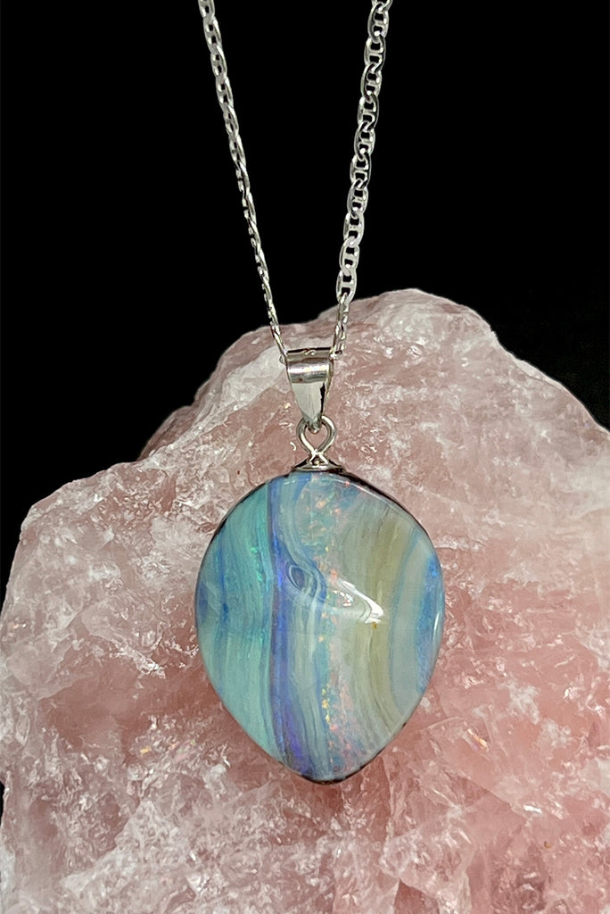 This Australian boulder Opal pendant is a beautiful feminine stone. It has a lovely sparkling flash of pink running from top to bottom, with mauve, green and blue on the sides. The surface is not flat but has a softly undulating surface.