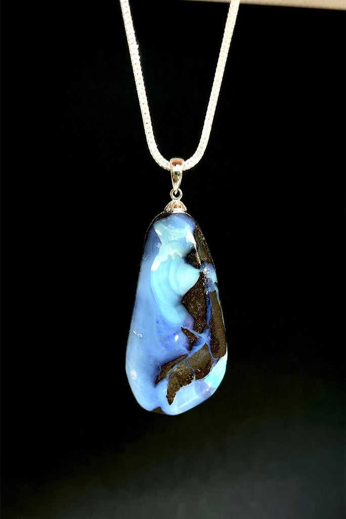 A very organic natural opal piece with strong blue colour meeting the boulder down one side, it looks like the meeting of the sea and the shore.