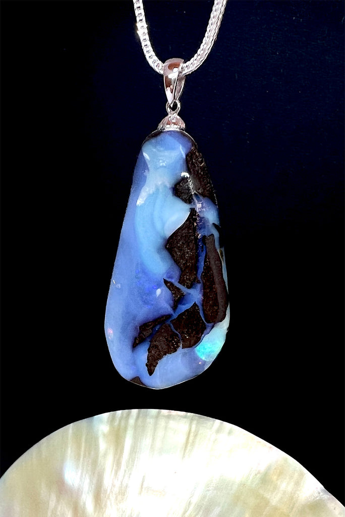 A very organic natural opal piece with strong blue colour meeting the boulder down one side, it looks like the meeting of the sea and the shore.