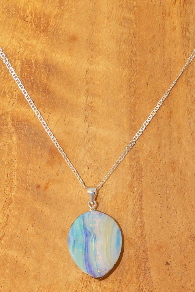 This Australian boulder Opal pendant is a beautiful feminine stone. It has a lovely sparkling flash of pink running from top to bottom, with mauve, green and blue on the sides. The surface is not flat but has a softly undulating surface.