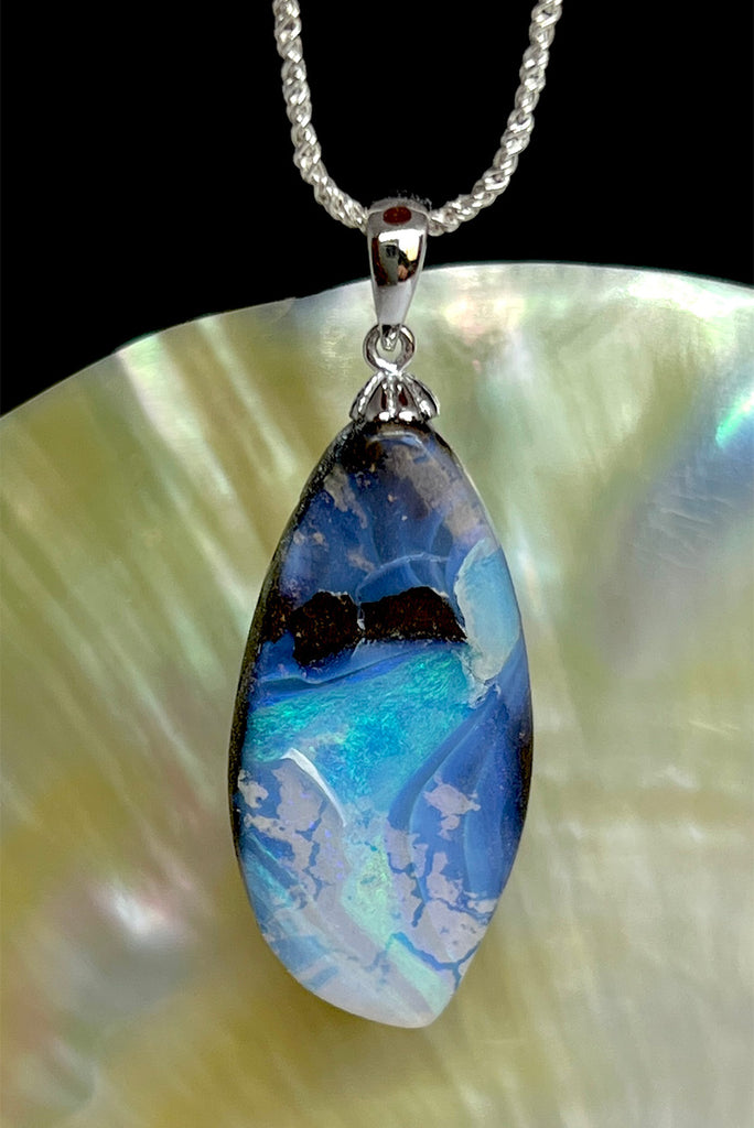 An organic natural piece featuring a small clear jelly opal detail on one side that reveals what is underneath. This piece has so much detail and depth.