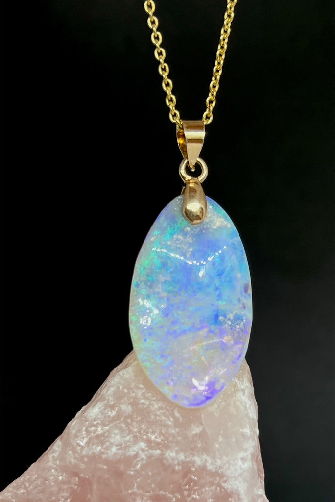 An opal pendant featuring a freeform droplet of Australian crystal opal cut and polished to reveal the pretty flecks of colour and sand through the stone. A one of a kind opal.