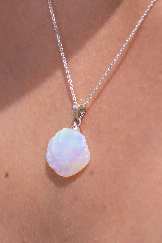 An opal pendant featuring a tiny carved seashell in Australian crystal opal. This is a very softly coloured piece with mauve, green and pink. A one of a kind opal. This piece has soft misty colouring, flecks of green, blue and mauve. Australian Crystal Opal.