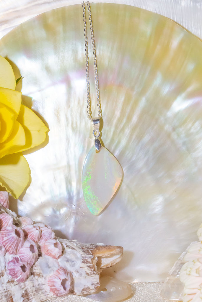 An opal pendant featuring a beautiful delicate whisper of Australian crystal opal cut and polished to reveal the flecks of colour through the stone. A one of a kind opal. This piece has soft mystical colouring, flecks of green, blue and a little mauve. Australian Crystal Opal.