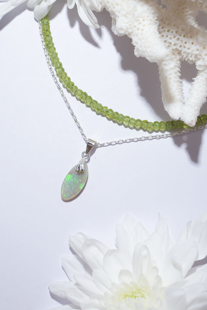 This delicate droplet of Australian Opal shimmers with swirling clouds of bright green fire.