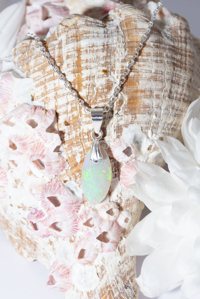 This delicate droplet of Australian Opal shimmers with swirling clouds of bright green fire.