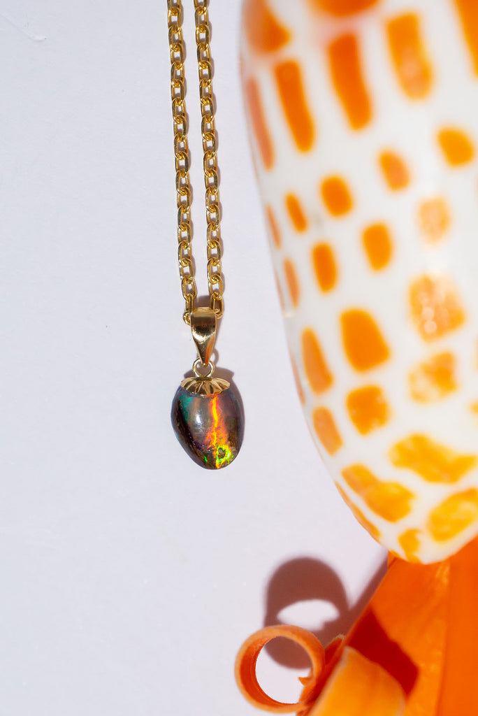 This petite Australian Boulder Opal pendant has extraordinary broad pattern colour flashes predominately green, gold & red. It is a truly special piece.