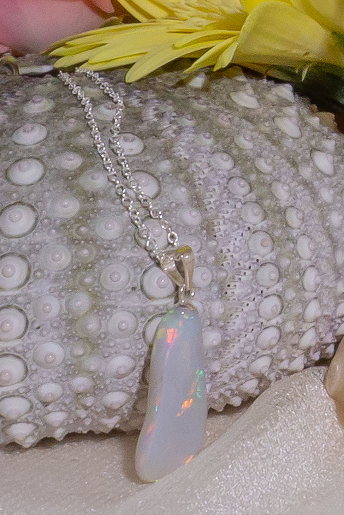 This quirky little opal pendant resembles a footprint left in the sand. It has a rolling rainbow flash down the stone.