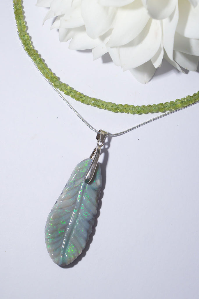 This exquisite feather pendant piece has been hand carved from solid Australian opal. Shimmering with flashes of green and aqua this is a truly unique piece of jewellery.