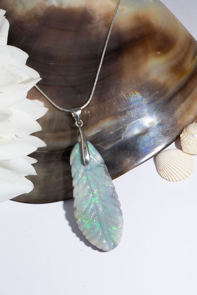 This exquisite feather pendant piece has been hand carved from solid Australian opal. Shimmering with flashes of green and aqua this is a truly unique piece of jewellery.