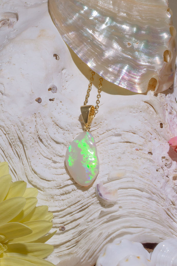 Australian solid crystal opal pendant cut into a freeform drop shape. Lovely bright green, flashing across the stone