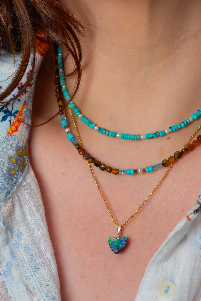 Flashes of bright green and blue, hidden depths and a rock pool. The ocean and the reef in this opal heart pendant.