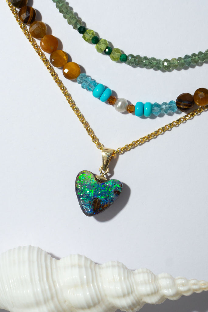 Flashes of bright green and blue, hidden depths and a rock pool. The ocean and the reef in this opal heart pendant.