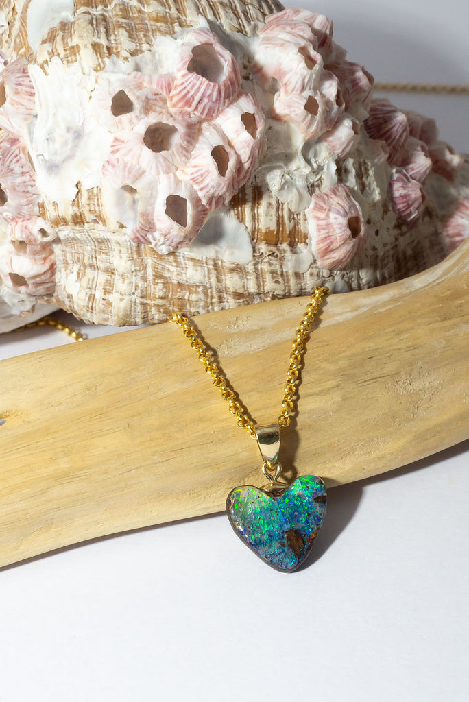 Flashes of bright green and blue, hidden depths and a rock pool. The ocean and the reef in this opal heart pendant.