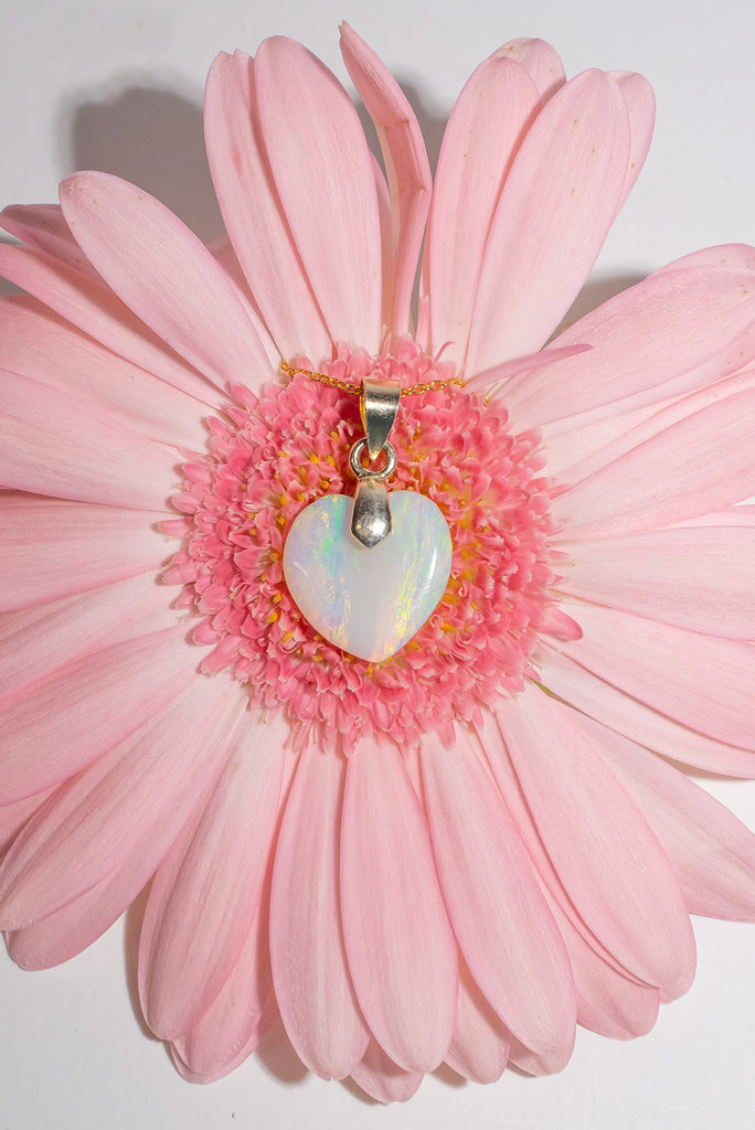 This is a really lovely opal heart pendant the crystal has shimmer in pink, green, and gold, the shape is very pure and harmonious. Romance in a stone.