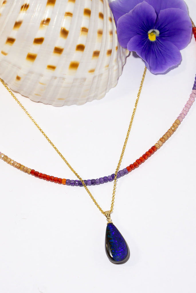 Where the ocean meets the sea, a lovely blue and dark silvery grey opal pendant. The dark ocean and rocks from above.