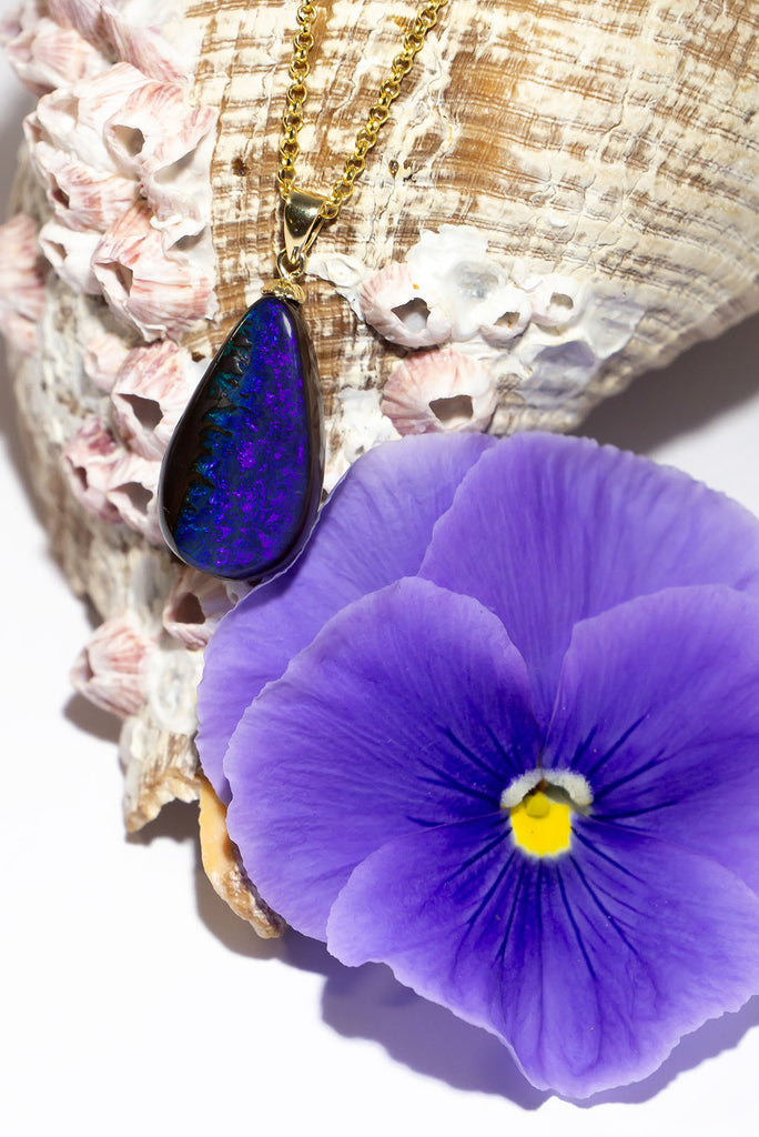Where the ocean meets the sea, a lovely blue and dark silvery grey opal pendant. The dark ocean and rocks from above.