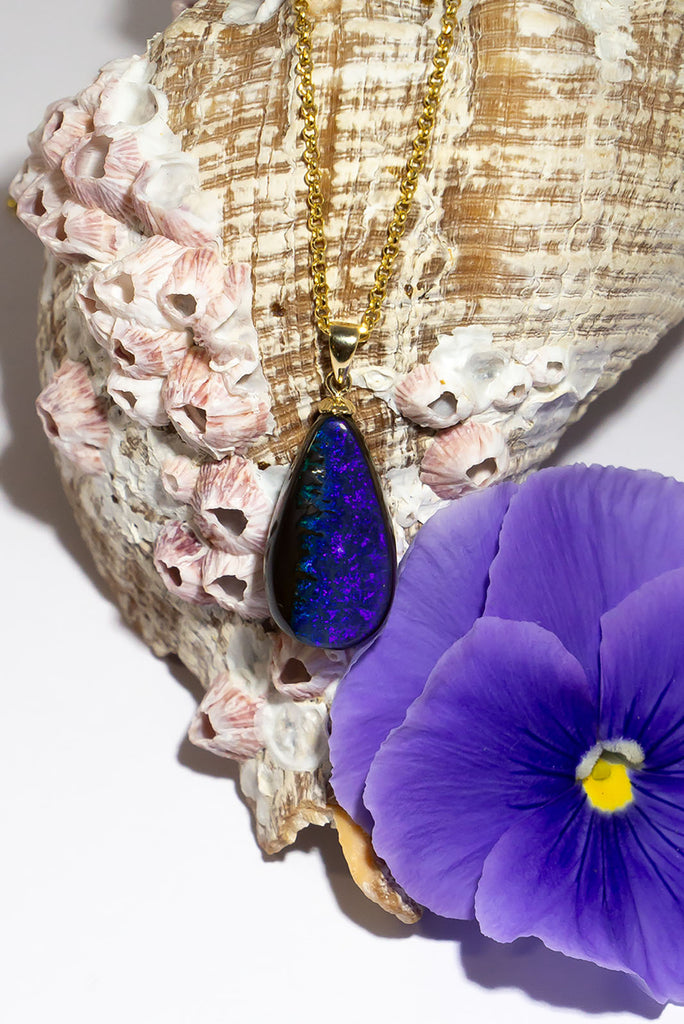 Where the ocean meets the sea, a lovely blue and dark silvery grey opal pendant. The dark ocean and rocks from above.