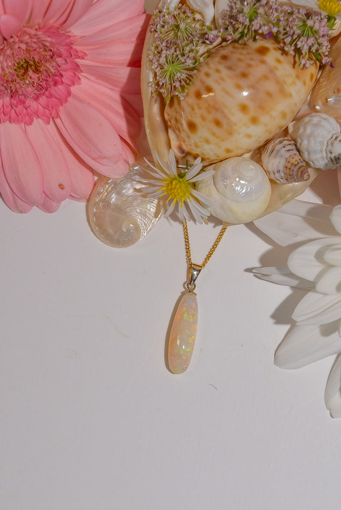A stunning opal pendant with sparkling crystal flecks and shimmer in pink, green, and gold, the shape is very pure and harmonious.&nbsp;
