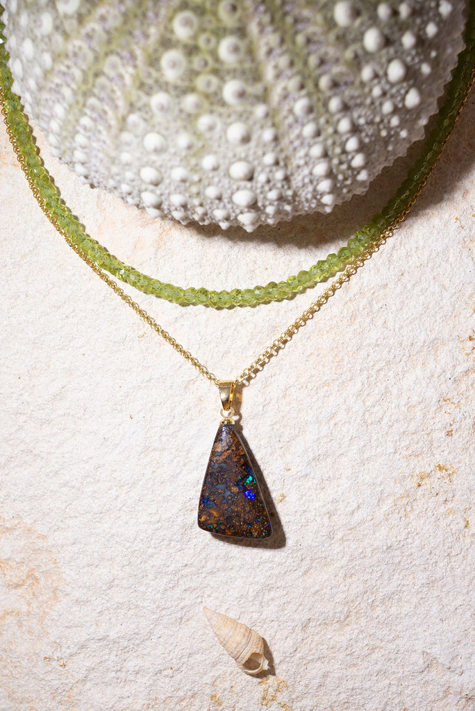 Discover a rainbow sparkle amongst the beautiful polished boulder stone of this pendant.