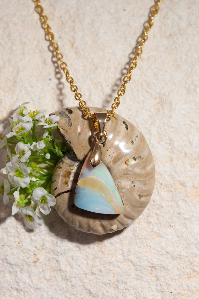 Echoing the gentle curve of a sandbank flowing out to sea, this sweet and subtle opal pendant has soft swirling shades of green and a little pink.