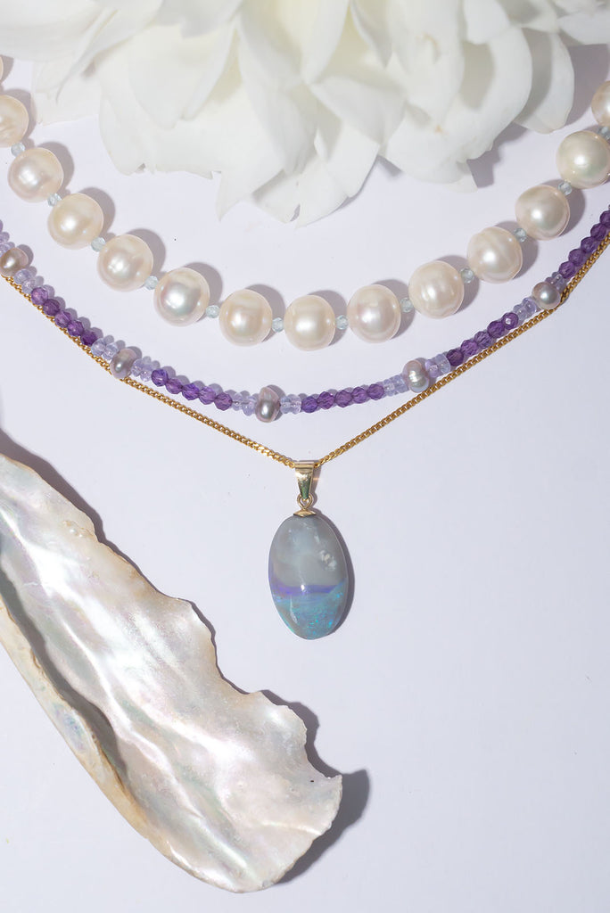 This delicate Australian opal pendant is reminiscent of a swirling sea fog as it meets the land. With a beautiful pool of shimmering colour play and a sky of softest grey.