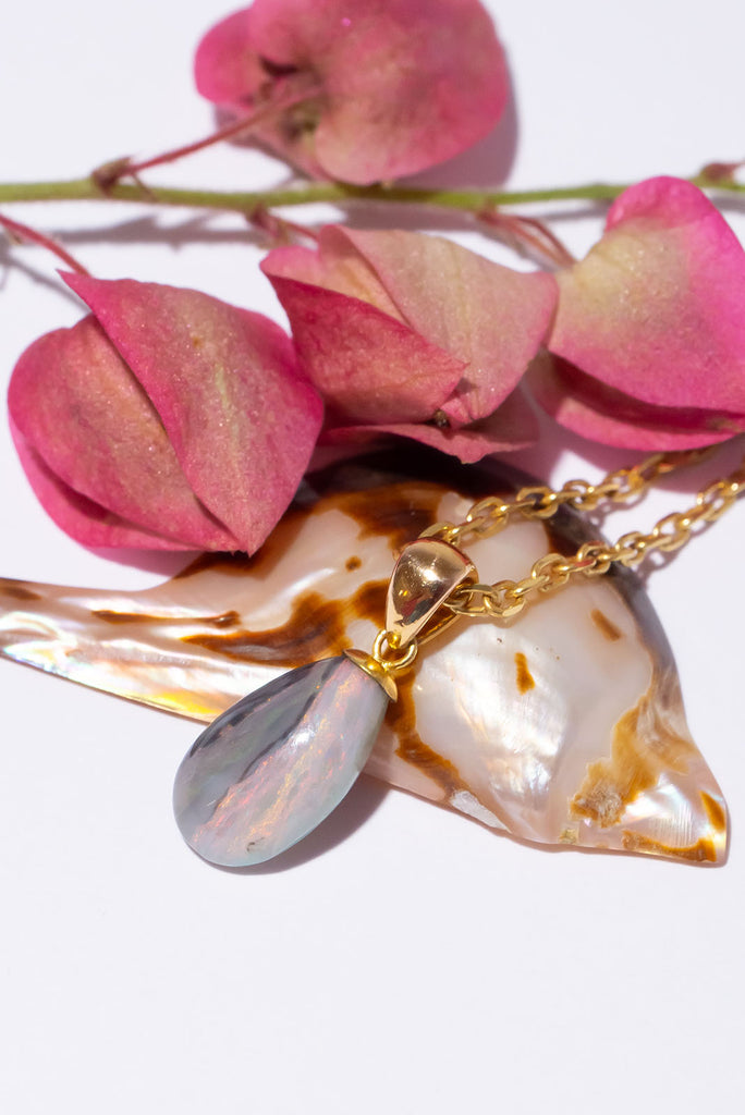 This subtly coloured opal has pink, green and some gold sprinkle running down the stone, the pretty rounded droplet shape perfectly follows the line.
