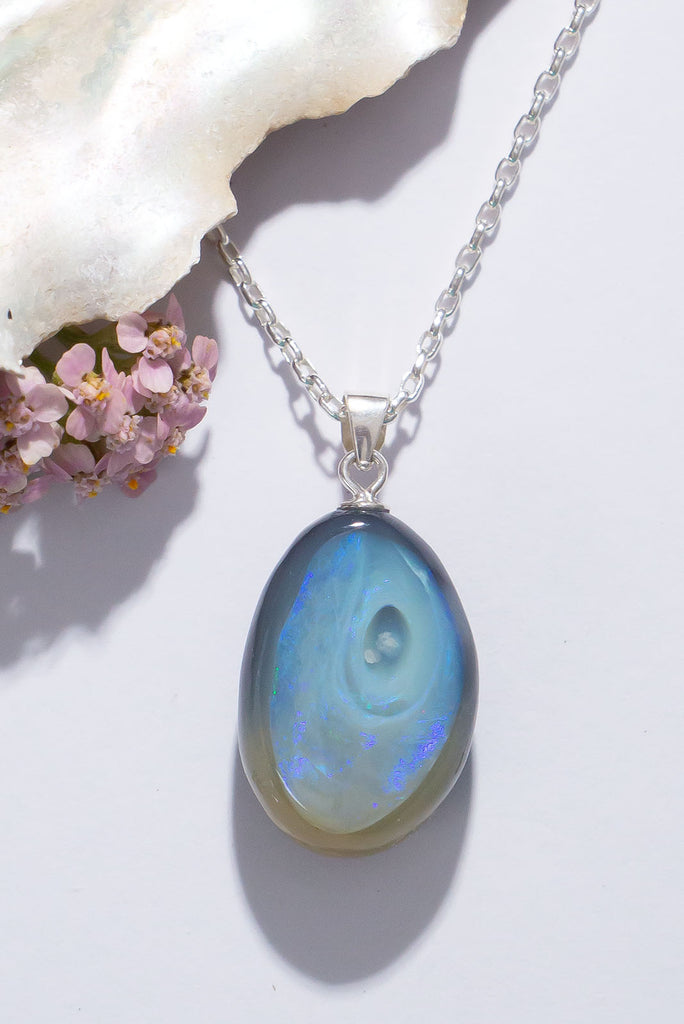 A swirling whirl of shimmering indigo fire in black and grey opal.