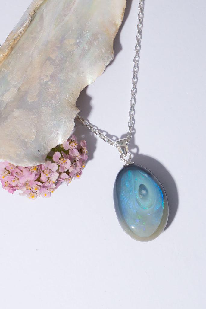 A swirling whirl of shimmering indigo fire in black and grey opal.