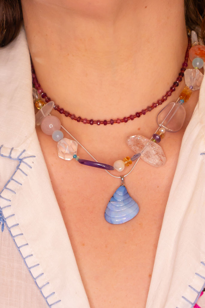 This truely unique pendant was hand carved in Noosa, Queensland. The soft sea shell shape is carved from a piece of Australian Boulder Opal that features shimmering flashes of blue and purple.&nbsp;