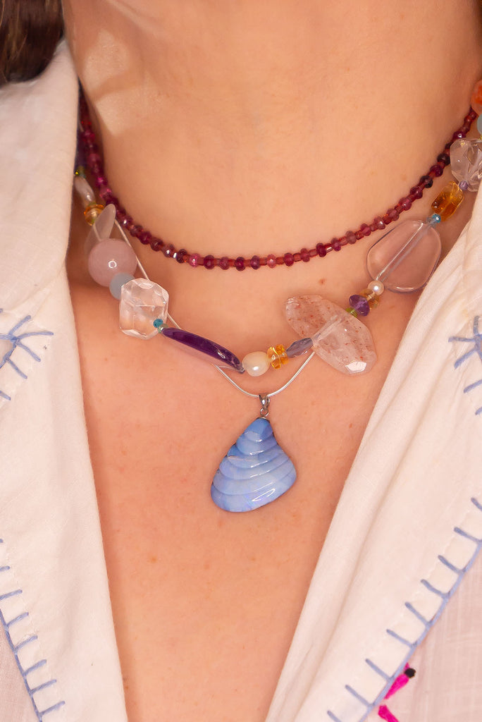 This truely unique pendant was hand carved in Noosa, Queensland. The soft sea shell shape is carved from a piece of Australian Boulder Opal that features shimmering flashes of blue and purple.&nbsp;
