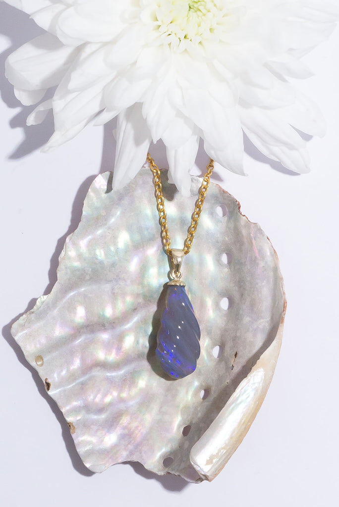 This gorgeous twist of Lightning Ridge Opal shimmers with enchanting flecks of dark blue & purple fire.