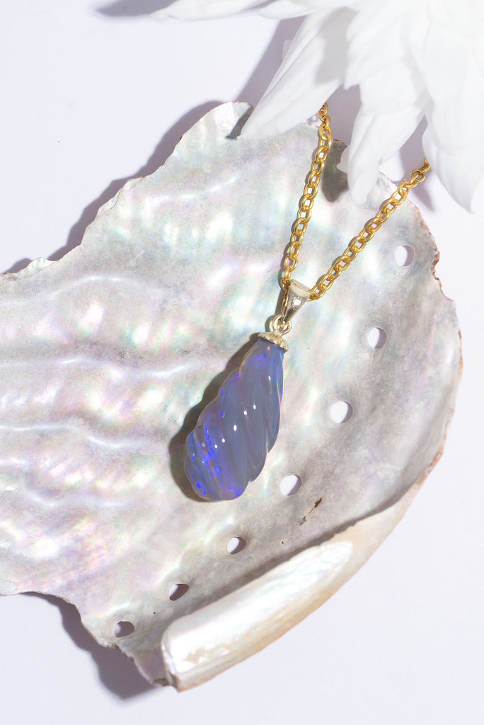 This gorgeous twist of Lightning Ridge Opal shimmers with enchanting flecks of dark blue & purple fire.
