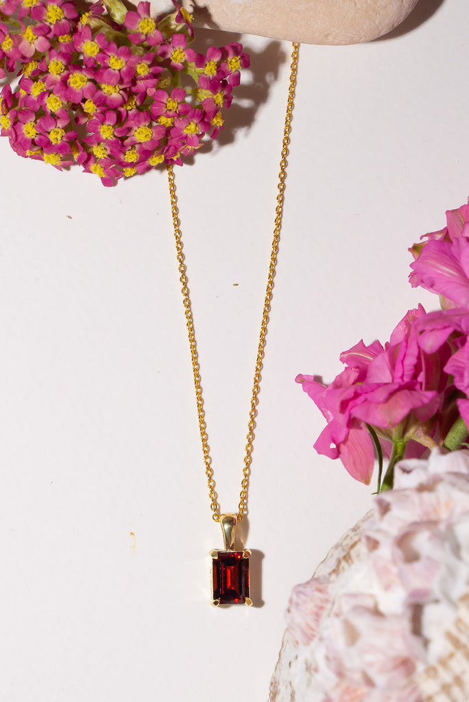 The pendant and chain are 9ct gold vermeil on a base of 925 silver, the gold is 2.5microns thick so will never rub or discolour. An emerald cut Garnet gemstone set in 9ct gold vermeil.