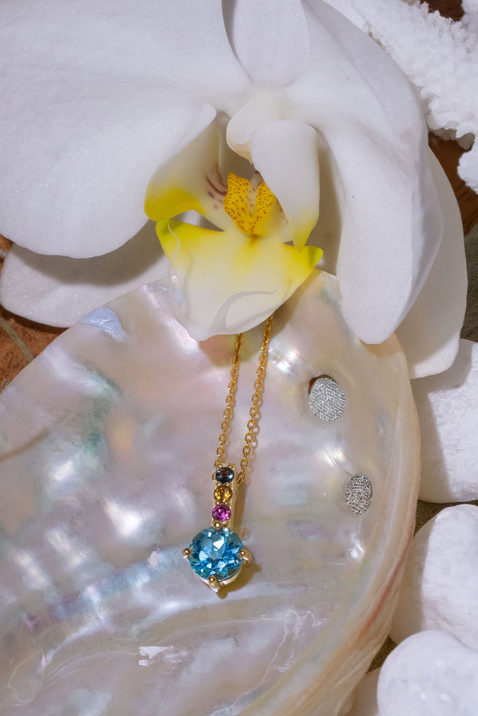 A pretty sparkling pendant featuring a round faceted Swiss Blue Topaz gemstone set in 9ct gold vermeil, the accent is a bar of tiny amethyst, citrine and blue topaz accent stones. 