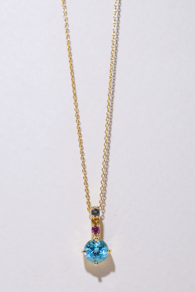 A pretty sparkling pendant featuring a round faceted Swiss Blue Topaz gemstone set in 9ct gold vermeil, the accent is a bar of tiny amethyst, citrine and blue topaz accent stones. 