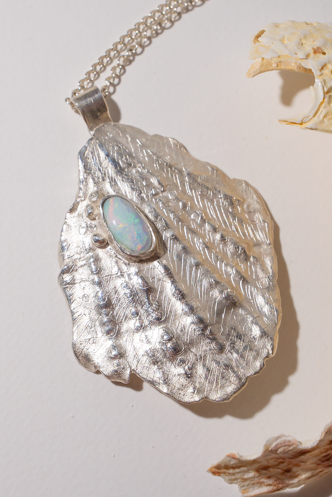 The pendant is solid silver, it is cast from an old sea worn shell and has a beautiful Australian opal set onto the front. This pendant is totally unique, it has the feeling of the spirit of the ocean